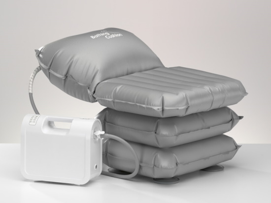 A triple-decker inflatable cushion with head support attached to a machanical pump